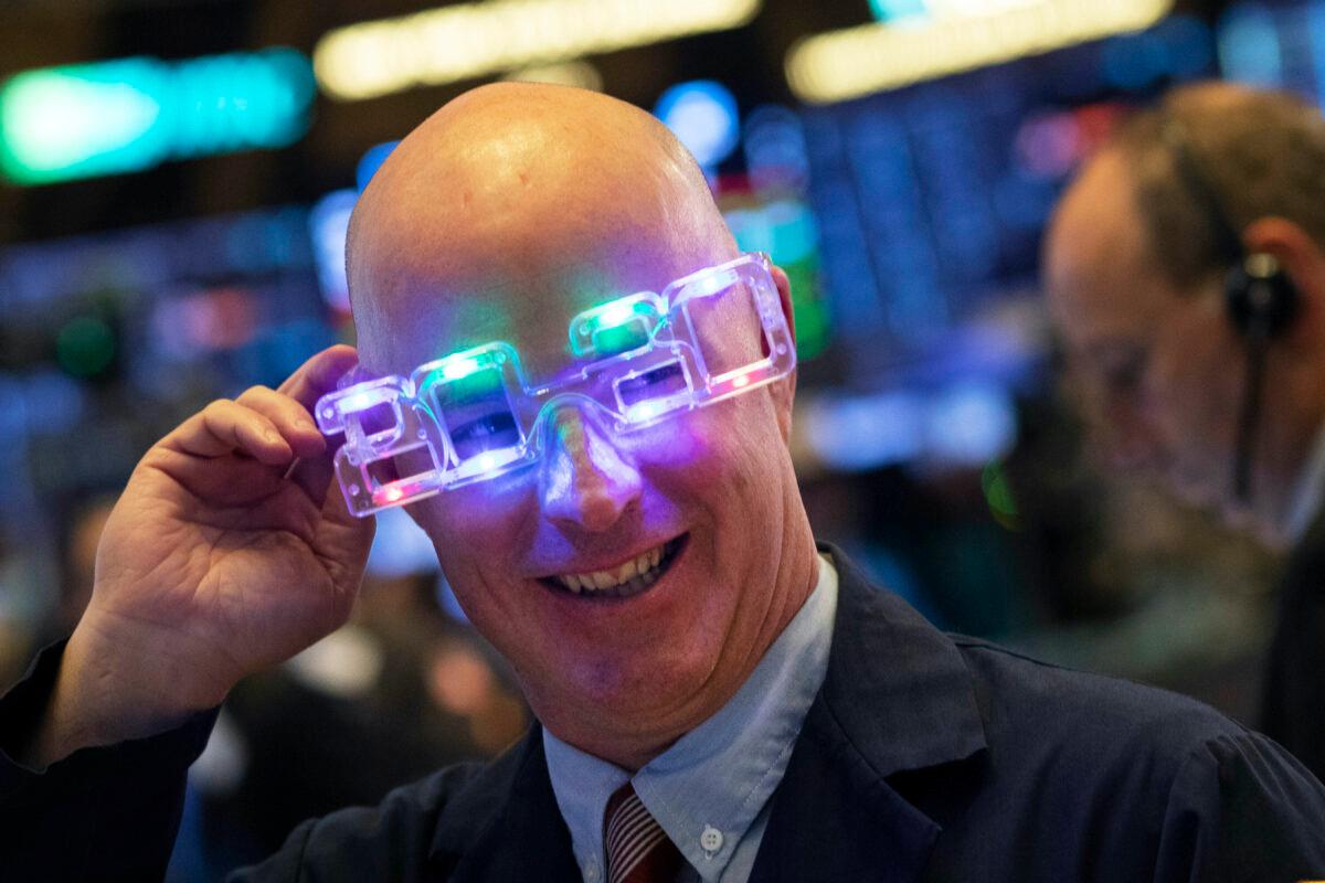 Stock trader John O'Hara tries on his New Year's 2020 party glasses at New York Stock Exchange, Tuesday, Dec. 31, 2019. (Mark Lennihan/AP)