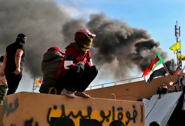 Pro-Iranian militiamen and their supporters set a fire during a demonstration in front of the U.S. embassy in Baghdad, Iraq, on Jan. 1, 2020. (Khalid Mohammed/AP Photo)