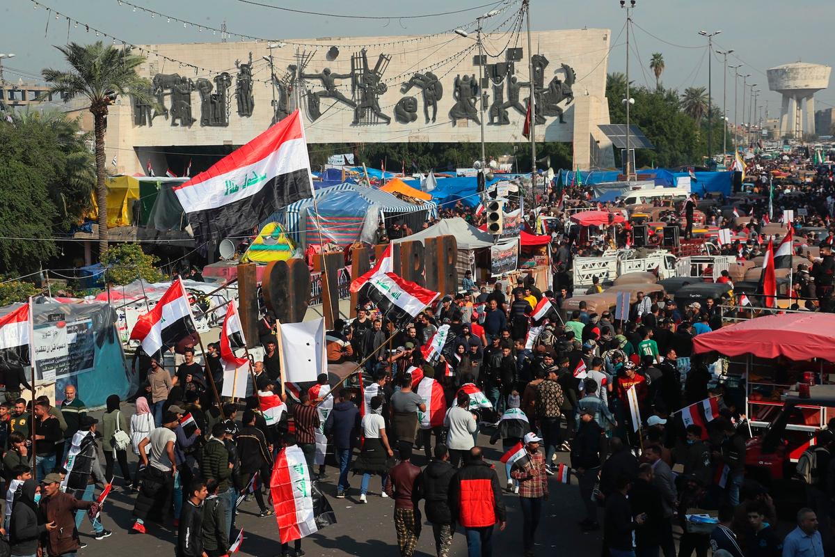 Hundreds of anti-government protesters march inside Tahrir Square carrying national flags and chanting religious slogans in Baghdad, Iraq on Dec. 5, 2019. (Hadi Mizban/AP Photo)
