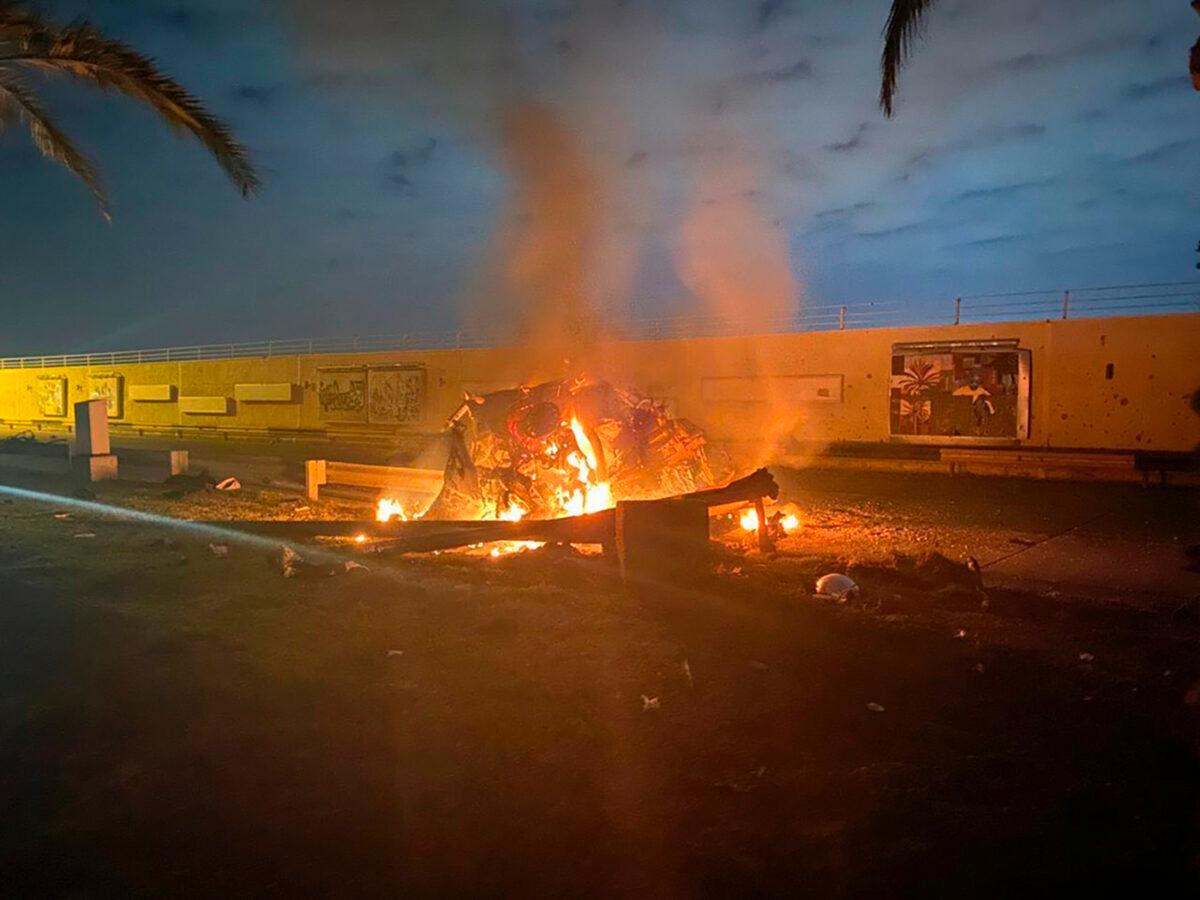 A photo released by the Iraqi Prime Minister Press Office shows a burning vehicle at the Baghdad International Airport following an airstrike, in Baghdad, Iraq, early on Jan. 2, 2020. (Iraqi Prime Minister Press Office via AP)