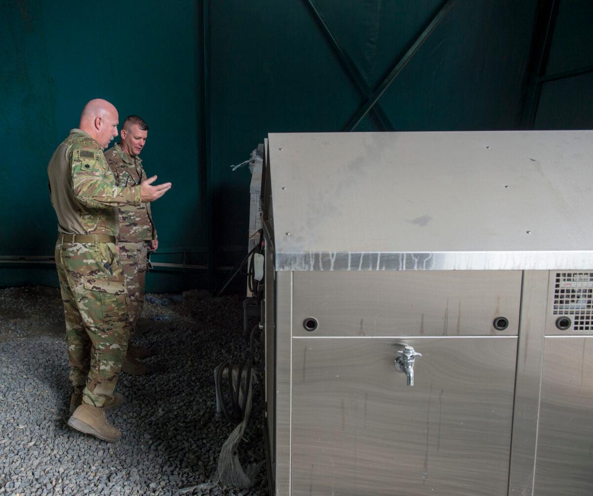 U.S. Air Force Lt. Col. Vance Goodfellow (L), 475th Expeditionary Air Base Squadron (EABS) commander, speaks with U.S. Army Lt. Col. Todd Martin (R), safety officer assigned to the Combined Joint Task Force-Horn of Africa (CJTF-HOA) Safety directorate, about water tanks during a battlefield circulation site visit at Camp Simba in Manda Bay, Kenya, on Feb. 24, 2018. (U.S. Air Force/Staff Sgt. Timothy Moore)