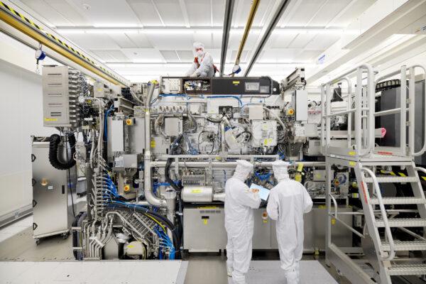 Employees are seen working on the final assembly of ASML's TWINSCAN NXE:3400B semiconductor lithography tool with its panels removed, in Veldhoven, Netherlands, on April 4, 2019. (Bart van Overbeeke Fotografie/ASML/Handout via Reuters)