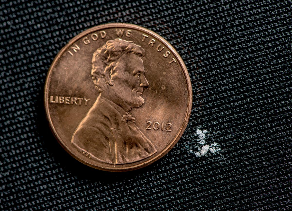 An illustration of two milligrams of fentanyl powder, a lethal dose, next to a one-penny coin. (DEA)