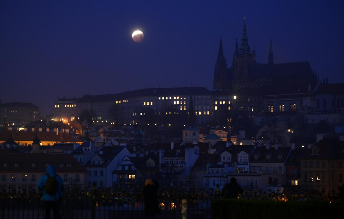 Earth's shadow engulfs a Super Blood Wolf Moon over the Prague Castle in the Czech capital of Prague during the lunar eclipse of Jan. 21, 2019. (©Getty Images | <a href="https://www.gettyimages.com/detail/news-photo/earths-shadow-moves-across-the-super-blood-wolf-moon-over-news-photo/1085731274?adppopup=true">MICHAL CIZEK</a>)
