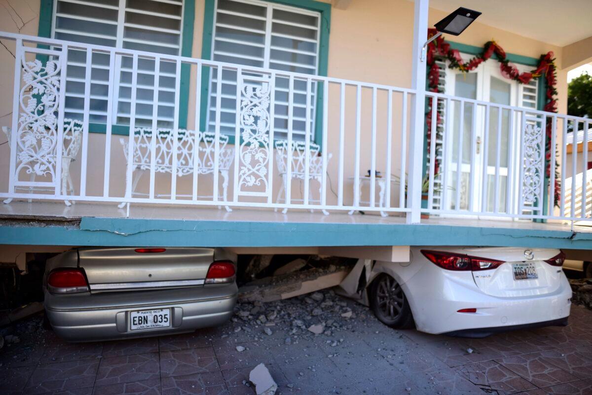 Cars are crushed under a home that collapsed after an earthquake hit Guanica, Puerto Rico, on Jan. 6, 2020. (Carlos Giusti/AP Photo)