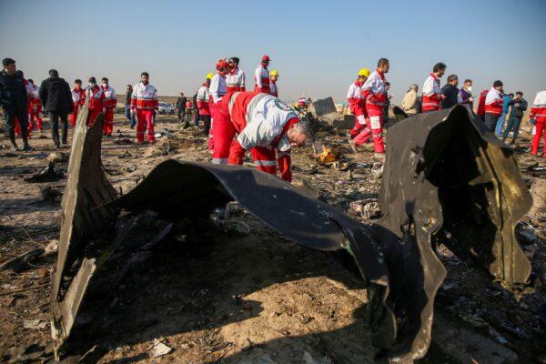 Red Crescent workers check the debris from the Ukraine International Airlines plane, that crashed after take-off from Iran's Imam Khomeini airport, on the outskirts of Tehran, Iran on Jan. 8, 2020. (Nazanin Tabatabaee/WANA (West Asia News Agency) via Reuters)