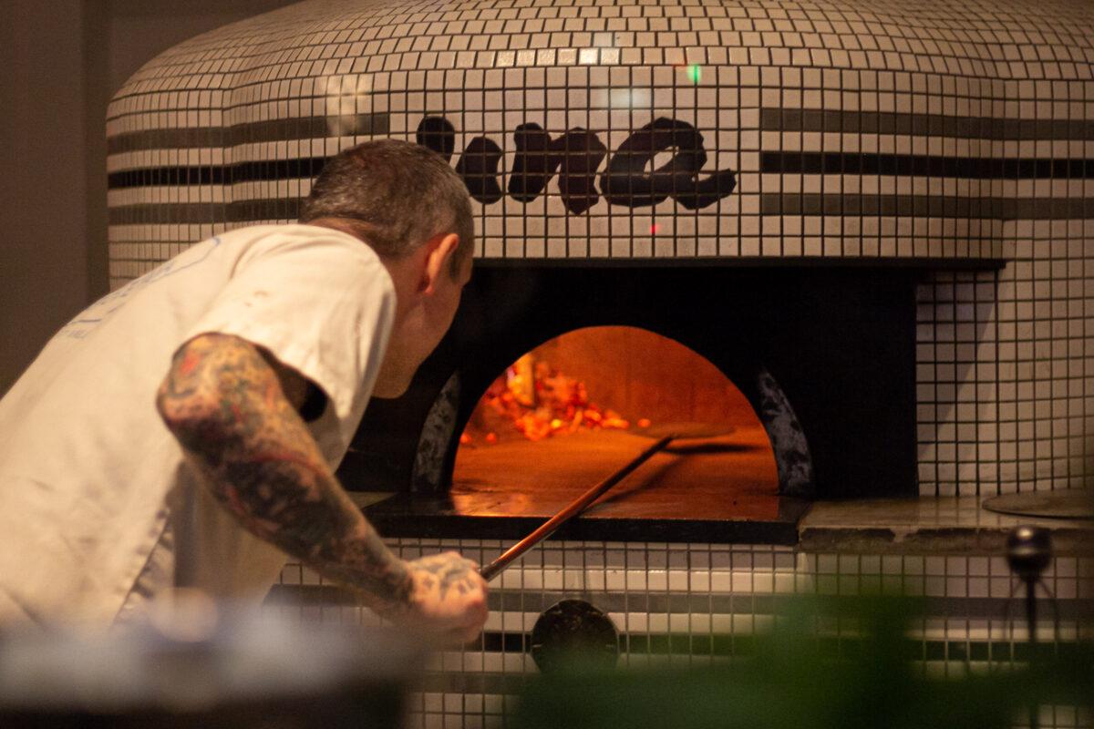 The pies are cooked in a wood-fired oven for 60–90 seconds. (Chung I Ho/The Epoch Times)