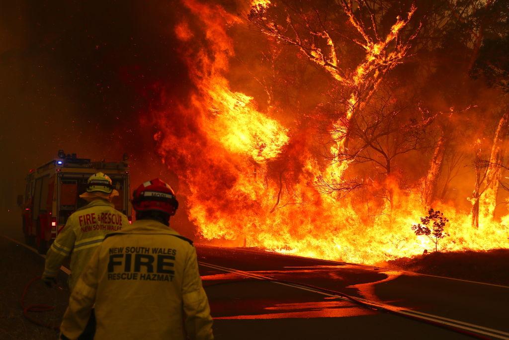 Fire and Rescue personal hurry to move their truck as a bushfire burns near the town of Bilpin in Sydney, Australia, on Dec. 19, 2019. (©Getty Images | <a href="https://www.gettyimages.com/detail/news-photo/fire-and-rescue-personnel-run-to-move-their-truck-as-a-news-photo/1194815190?adppopup=true">David Gray</a>)