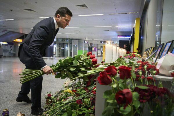 In this handout photo provided by the Ukrainian Presidential Press Office, Ukrainian President Volodymyr Zelenskiy lays flowers at a memorial of the flight crew members of the Ukrainian 737-800 plane that crashed on the outskirts of Tehran, at Borispil international airport outside in Kyiv, Ukraine on Jan. 9, 2020. (Ukrainian Presidential Press Office via AP)