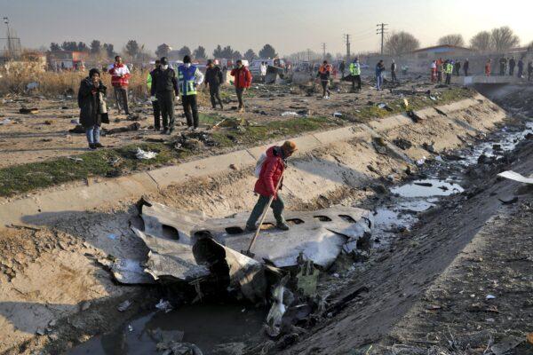 Rescue workers inspect the scene where a Ukrainian plane crashed in Shahedshahr, southwest of the capital Tehran, Iran on Jan. 8, 2020. (Ebrahim Noroozi/AP Photo)
