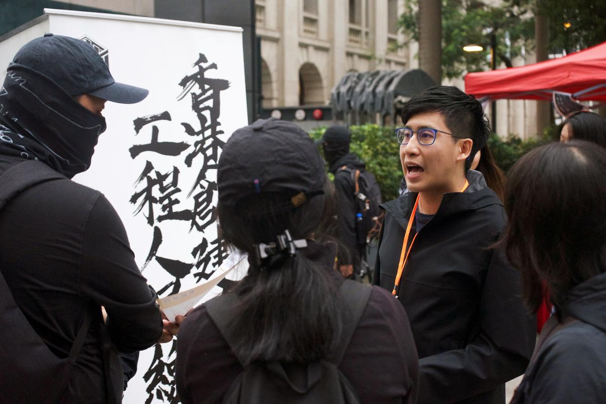 Chris Ngai, Chairman of Hong Kong Construction and Engineering Employees General Union, talks to people near his union’s recruitment booth set up along the route of the New Year pro-democracy march in Hong Kong, China on Jan. 1, 2020. (Sarah Wu/Reuters)