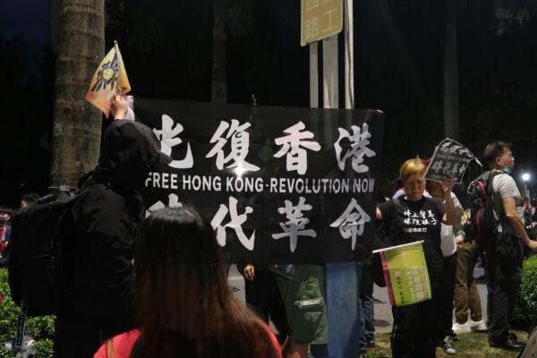 Hongkongers hold up a black banner with the words "Liberate Hong Kong, Revolution of Our Times" at a Taipei rally on Jan. 10, 2020. (Frank Fang/The Epoch Times)