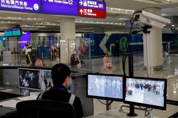 A health surveillance officer monitors passengers arriving at the Hong Kong International airport on Jan. 4, 2020. (AP Photo/Andy Wong, File)
