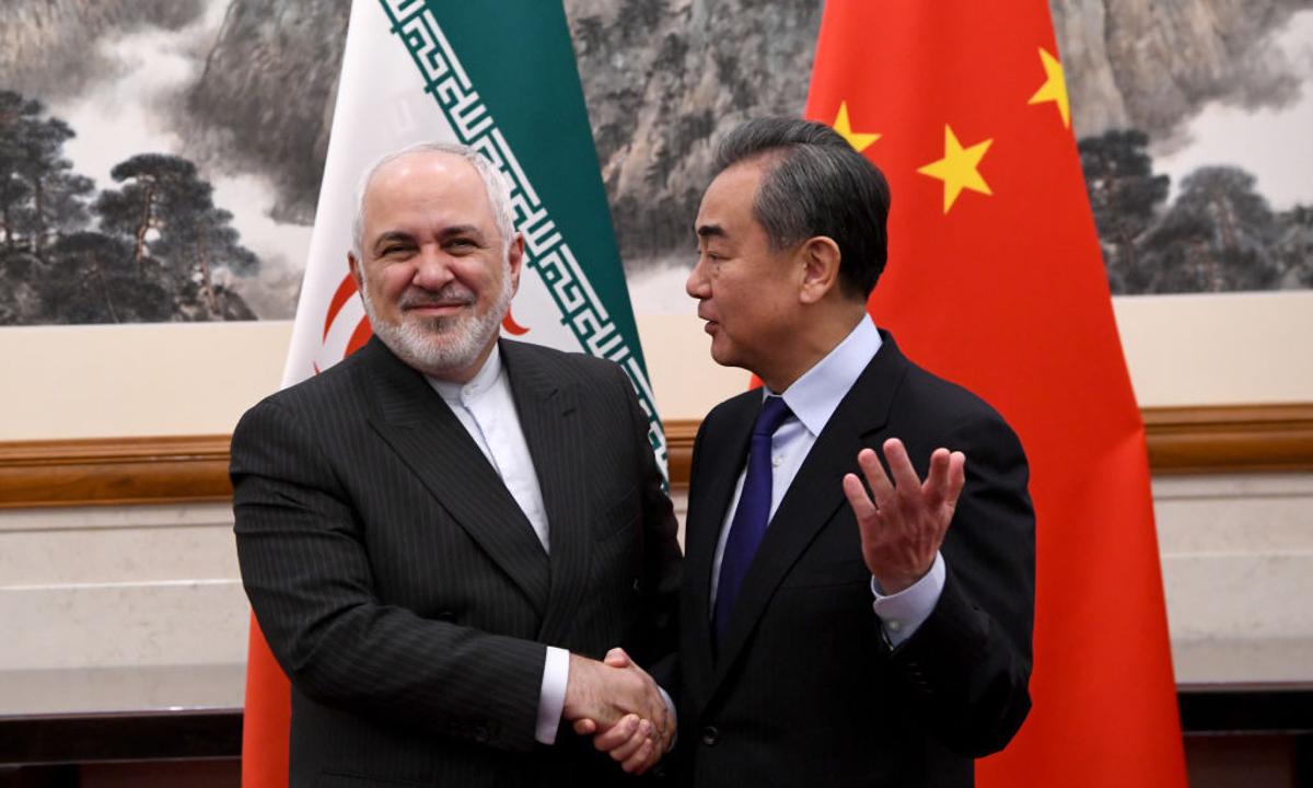 China's Foreign Minister Wang Yi shakes hands with Iran's Foreign Minister Mohammad Javad Zarif during a meeting at the Diaoyutai state guest house in Beijing on Dec. 31, 2019. (Noel Celis-Pool/Getty Images)