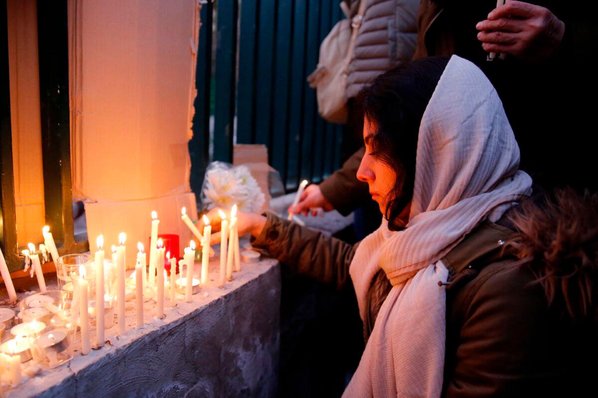 An Iranian lights candles for the victims of Ukraine International Airlines Boeing 737 during a gathering in front of the Amirkabir University in the capital Tehran, on Jan. 11, 2020. (AFP via Getty Images)