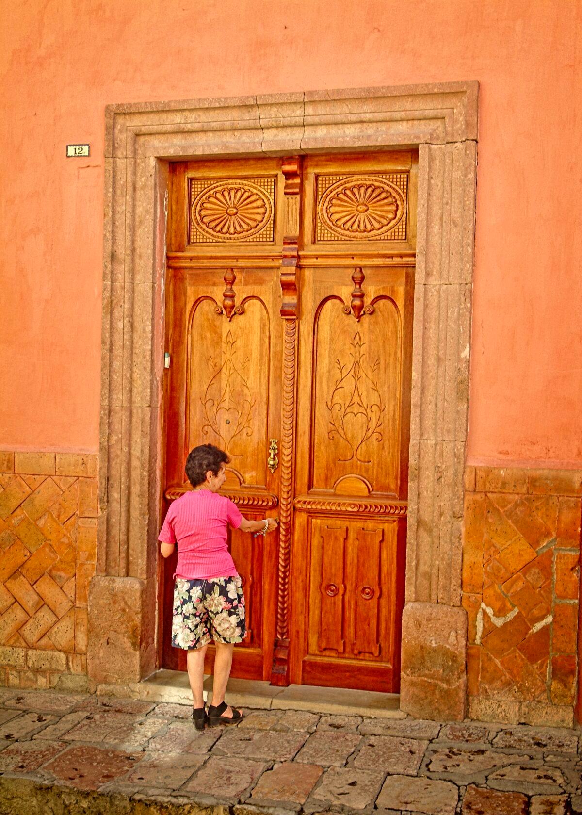 The Spanish colonial era door to this woman’s home in the historic district of San Miguel de Allende is over twice as tall as she is. (Fred J. Eckert)