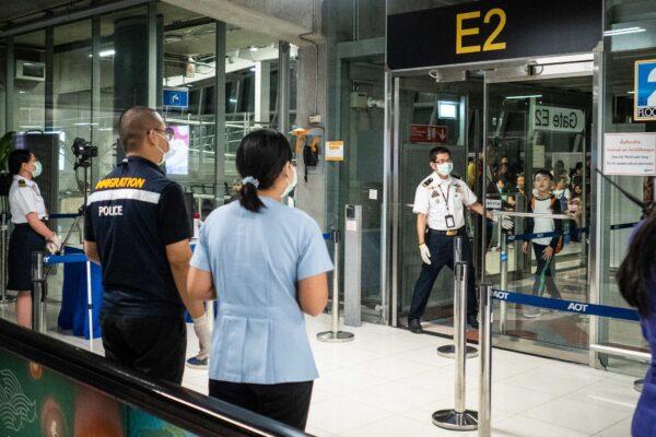 Public health officials hand out disease monitoring information after performing a thermal scans on passengers arriving from Wuhan, China at Suvarnabhumi Airport in Bangkok, Thailand, on Jan. 8, 2020. (Lauren DeCicca/Getty Images)