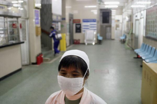 A nurse wearing a face mask walks in a hallway of a hospital in Guangzhou, China, on Jan. 13, 2004. (Getty Images)