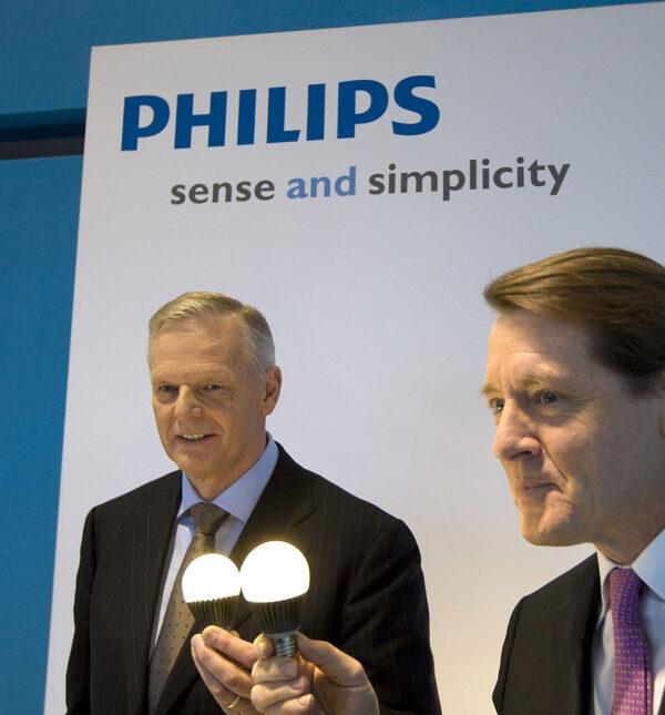 Philips President and CEO Gerard Kleisterlee (L), and CFO Pierre-Jean Sivignon display two low-energy light bulbs during a press conference in Amsterdam on Jan. 25, 2010. (Marcel Antonisse/AFP via Getty Images)