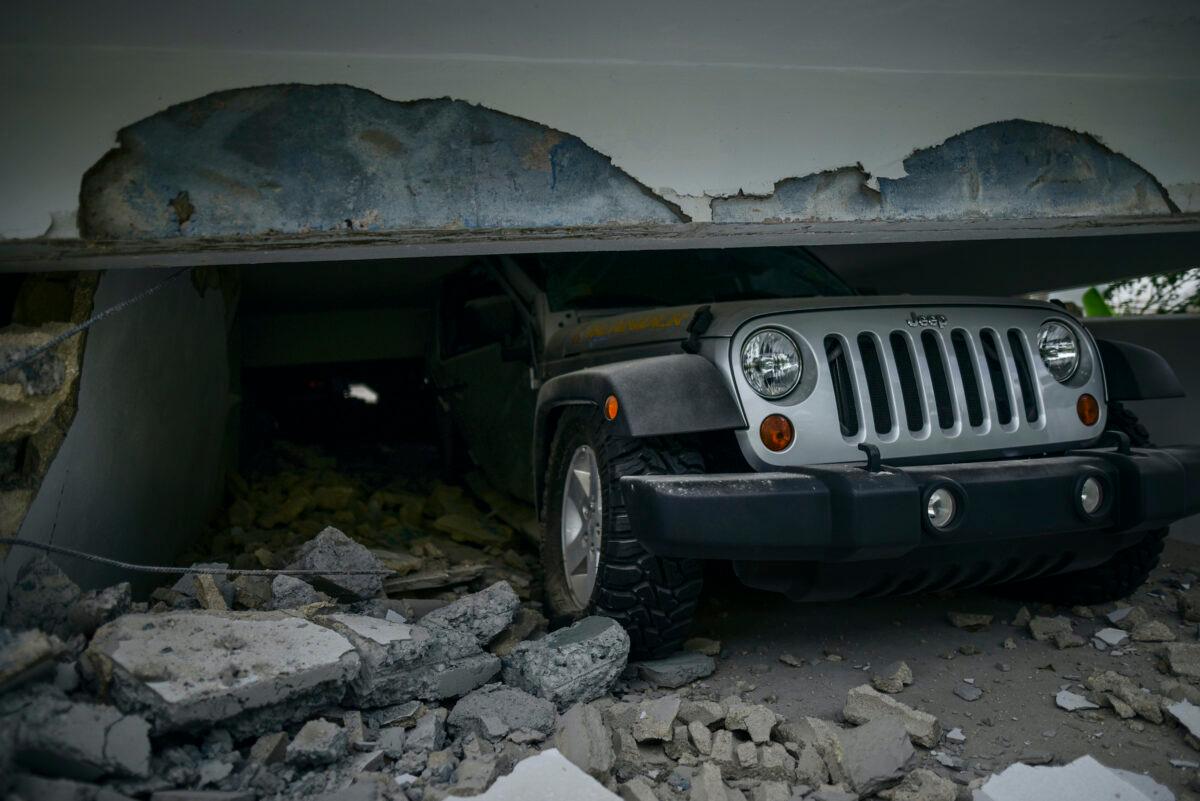 A car is crushed under a home that collapsed after the previous day's magnitude 6.4 earthquake in Yauco, Puerto Rico on Wednesday, Jan. 8, 2020. (Carlos Giusti/AP)