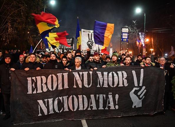 People hold a banner reading "The Heroes never die" as they march in the memory of the people who lost their lives during the 1989 Revolution in Timisoara on Dec. 16, 2019, as the city commemorates 30 years since the bloody anti-communist uprising that paved the way for democracy in Romania. (DANIEL MIHAILESCU/AFP via Getty Images)