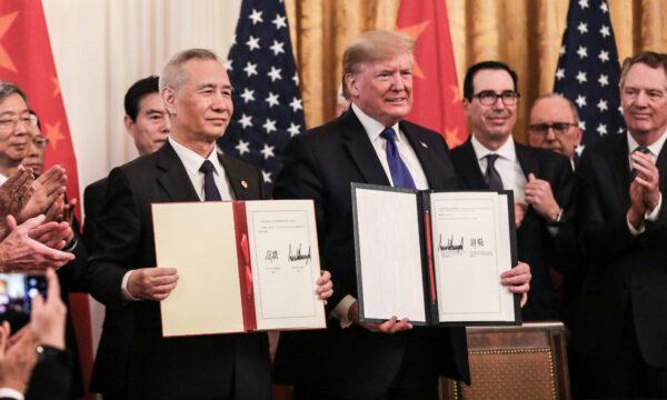 Then-Chinese Vice Premier Liu He and then-U.S. President Donald Trump during the signing of phase one of a trade deal, surrounded by officials, in the East Room of the White House in Washington, on Jan. 15, 2020. (Charlotte Cuthbertson/The Epoch Times)
