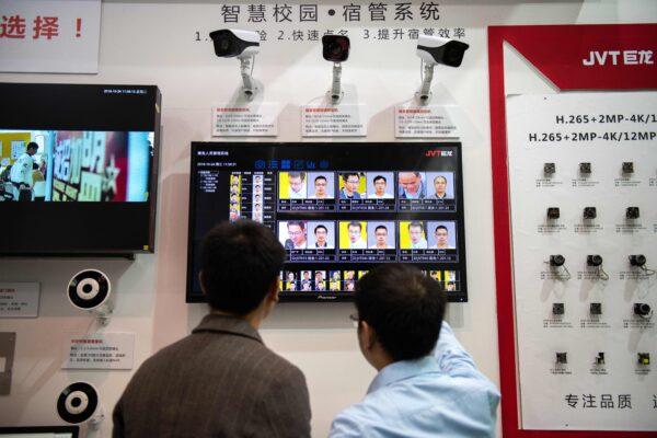 Visitors look at AI (artificial intelligence) security cameras with facial recognition technology at the 14th China International Exhibition on Public Safety and Security at the China International Exhibition Center in Beijing, China, on Oct. 24, 2018. (Nicolas Asfouri/AFP via Getty Images)