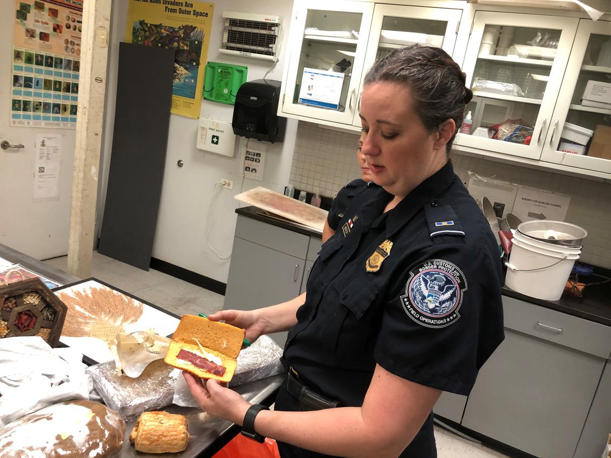 Jessica Anderson, an agricultural specialist for U.S. Customs Border and Protection, shows a pork sandwich confiscated from a traveler arriving from Shanghai at O'Hare International Airport in Chicago, Illinois, U.S. on Oct. 9, 2019. (Tom Polansek/Reuters)