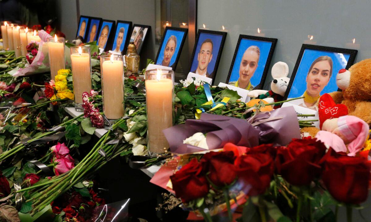 Flowers and candles are placed in front of portraits of the flight crew members of the Ukrainian 737-800 plane shot down by the Iranian military on the outskirts of Tehran, at a memorial inside Borispil international airport outside Kyiv, Ukraine, on Jan. 11, 2020. (Efrem Lukatsky/AP Photo)