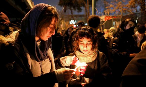 People gather in front of Amir Kabir University for a candlelight vigil to remember the victims of the Ukrainian airplane shot down by the Iranian military, in Tehran, Iran, on Jan. 11, 2020. (Ebrahim Noroozi/AP Photo)