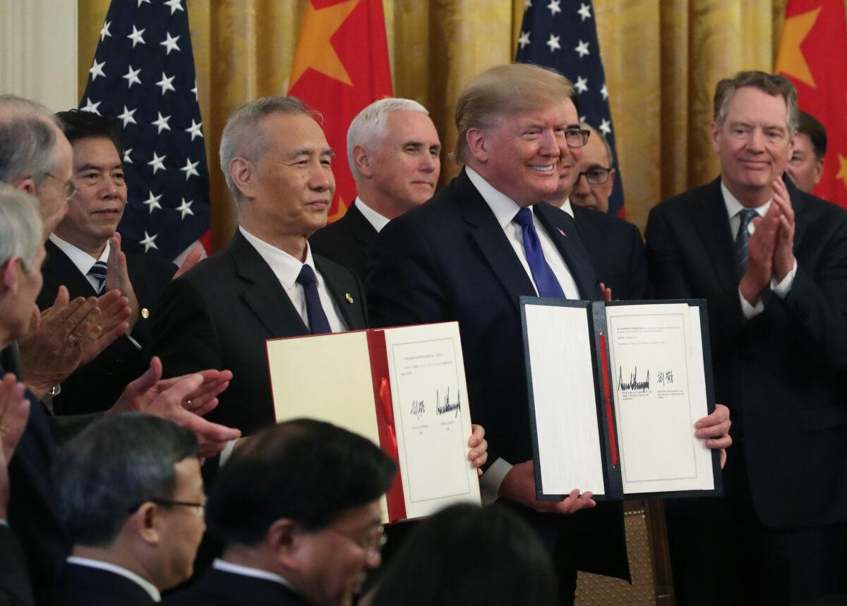 U.S. President Donald Trump and Chinese Vice Premier Liu He hold up signed agreements of phase 1 of a trade deal between the United States and China, in the East Room at the White House in Washington on Jan. 15, 2020. (Mark Wilson/Getty Images)