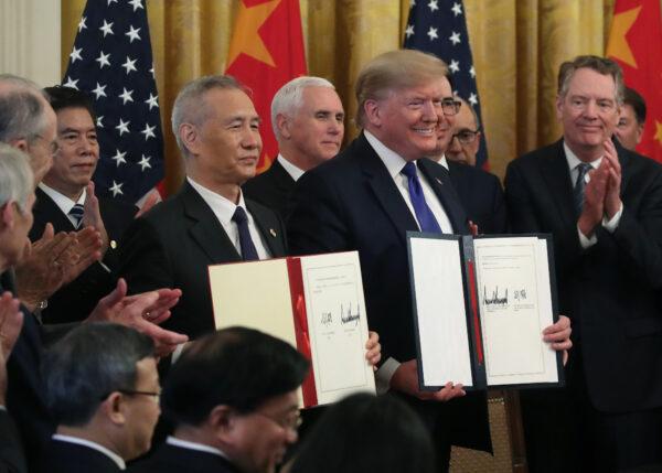 U.S. President Donald Trump and Chinese Vice Premier Liu He hold up signed agreements of phase one of a trade deal between the United States and China, in the East Room at the White House in Washington on Jan. 15, 2020. (Mark Wilson/Getty Images)