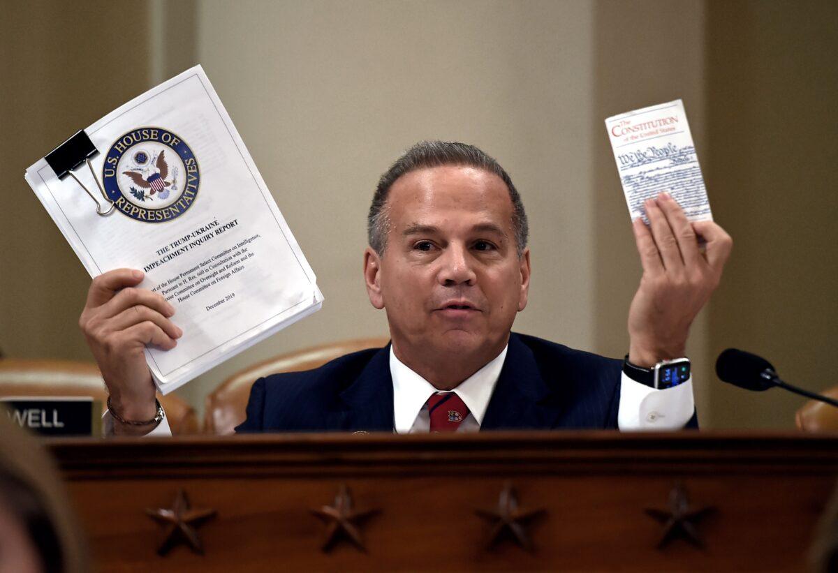 Rep. David Cicilline (D-R.I.) holds up a copy of the Trump-Ukraine Impeachment inquiry report and a copy of the Constitution of the United States as the U.S. House Committee on the Judiciary marks-up House Resolution 755, Articles of Impeachment Against President Donald J. Trump, in the Longworth House Office Building in Washington on Dec. 12, 2019. (Olivier Douliery/AFP via Getty Images)