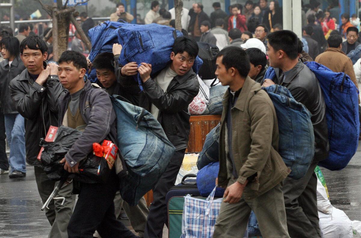 Chinese migrant workers arrive to board a train at Shanghai station before returning to their hometowns for the Chinese New Year holiday, in Shanghai, China, on Feb. 8, 2007. (Mark Ralston/AFP via Getty Images)