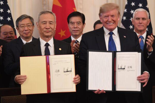 Chinese Vice Premier Liu He and U.S. President Donald Trump display the signed trade agreement between the United States and China in the East Room of the White House in Washington, D.C., on Jan. 15, 2020. (Saul Loeb/AFP via Getty Images)