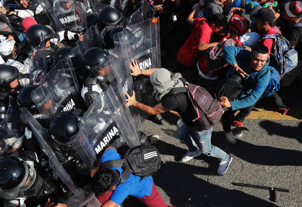 Migrants charge on Mexican National Guardsmen at the border crossing between Guatemala and Mexico in Tecun Uman, Guatemala, on Jan. 18, 2020. (Marco Ugarte/AP Photo)