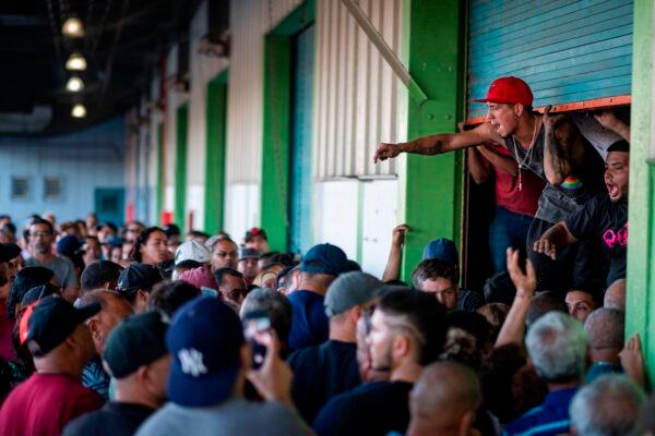 People break into a warehouse with supplies believed to have been from when Hurricane Maria struck the island in 2017, in Ponce, Puerto Rico on Jan. 18, 2020. (Ricardo Arduengo/AFP/Getty Images)