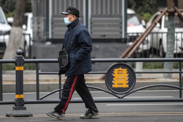An elderly man wears a mask while walking past the closed Huanan Seafood Wholesale Market, which has been linked to cases of Coronavirus, in Wuhan, Hubei province, China, on Jan. 17, 2020. (Getty Images)