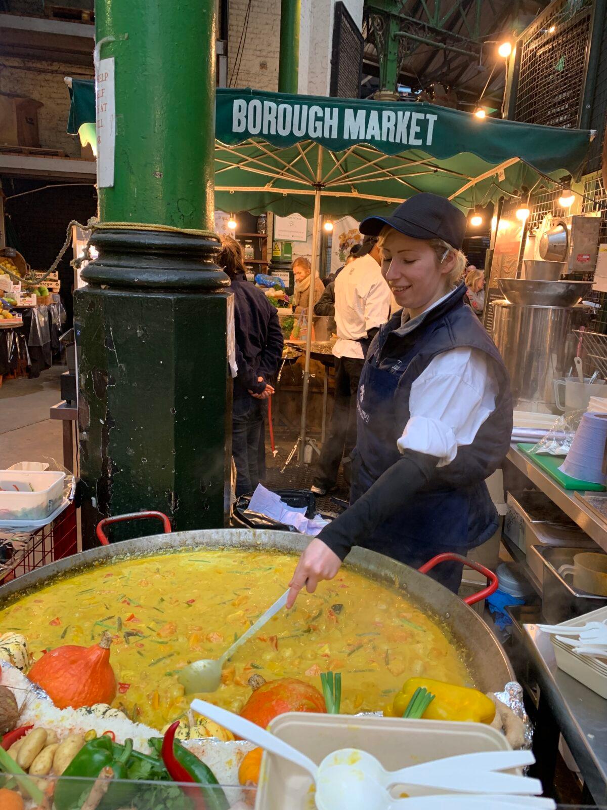 A chef cooks a big pot of curry at a market. (Lisa Sim)