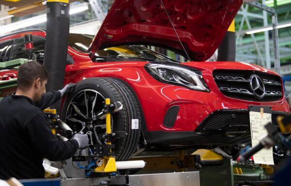 An employee mounts a wheel on a Mercedes Benz A Class on the assembly line at the Daimler AG factory in Rastatt, Germany, on Feb. 4, 2019. (Thomas Kienzle/AFP via Getty Images)