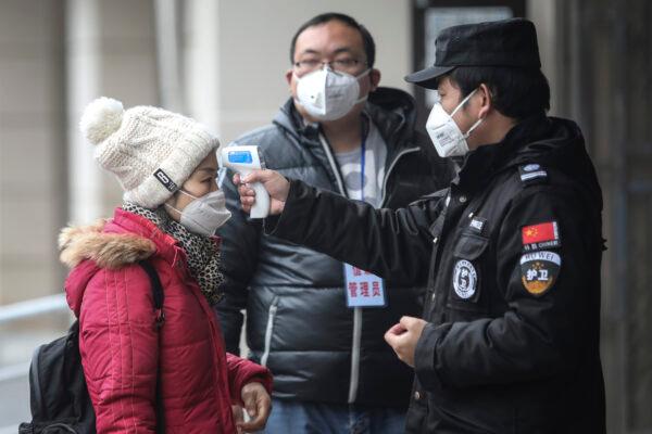 Security personnel check the temperature of passengers in the Wharf at the Yangtze River in Wuhan city, Hubei province, China, on January 22, 2020. (Photo by Getty Images)