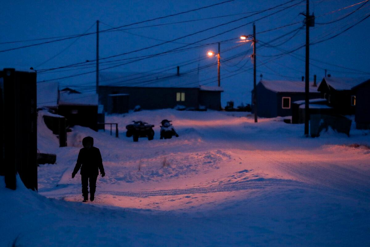 A woman walks before dawn in Toksook Bay, Alaska, a mostly Yuip'ik village on the edge of the Bering Sea on Jan. 20, 2020. (Gregory Bull/AP Photo)
