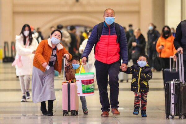  Commuters wearing face masks walk in Hankou railway station in Wuhan, in China's central Hubei province on Jan. 21, 2020. (AFP via Getty Images)