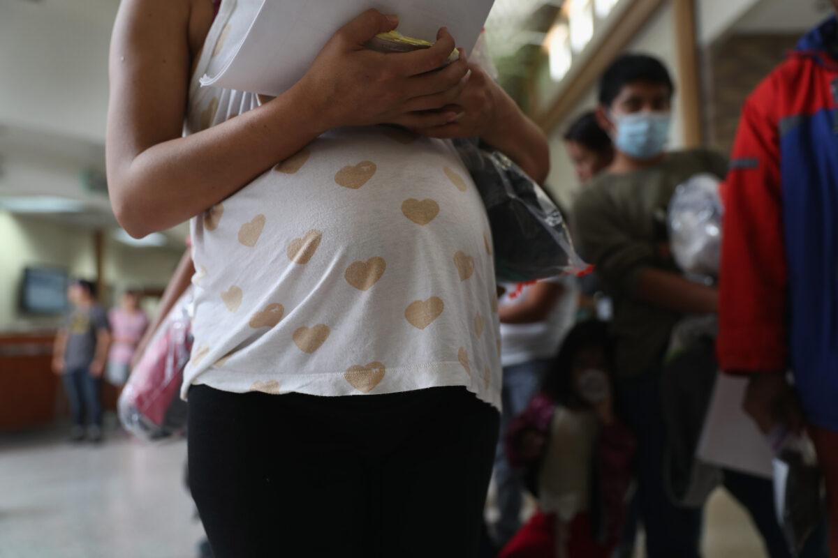 A pregnant Honduran migrant stands in line with other migrants for a bus to another place inside the United States, in McAllen, Texas, on Aug. 15, 2016. (John Moore/Getty Images)