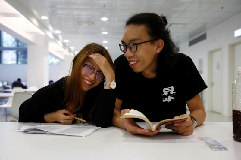 Derek Tai and his girlfriend Ann react inside a library at Chinese University of Hong Kong in Hong Kong, China, on Jan. 15, 2020. (Tyrone Siu/Reuters)