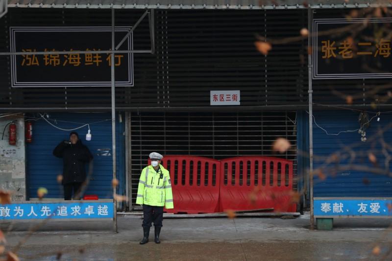 A police officer wearing a mask stands in front of the closed seafood market in Wuhan, Hubei province, China on Jan. 10, 2020. (Stringer/Reuters