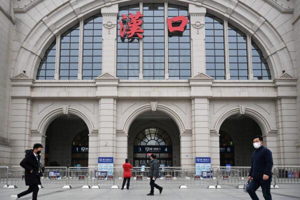 People walk past the closed Hankou Railway Station after the city was locked down following the outbreak of a new coronavirus in Wuhan, Hubei Province, China on Jan. 23, 2020. (China Daily via Reuters)