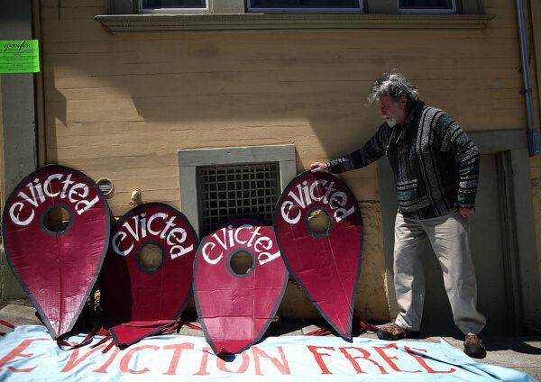A protester props up a sign during a demonstration on July 29, 2014 outside of an apartment building that allegedly evicted all of the tenants to convert the units to AirBnb rentals in San Francisco, California. (Justin Sullivan/Getty Images)