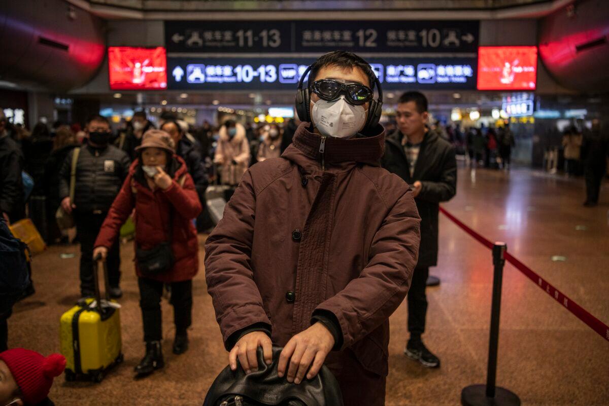 A Chinese man wears a protective mask and glasses before boarding a train at a railway station in Beijing, China on Jan. 23, 2020. (Kevin Frayer/Getty Images)