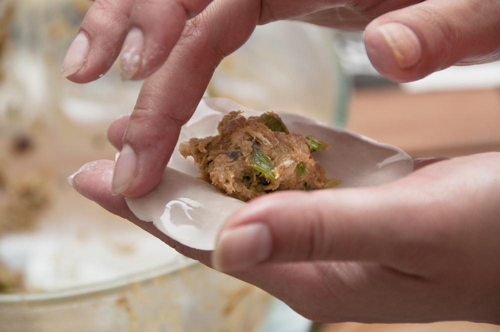 Filling and sealing each dumpling wrapper. (Shutterstock)